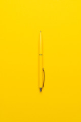 yeloow ballpoint pen on the yellow background
