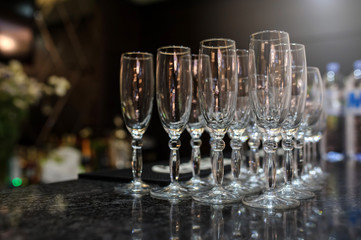 close up photo of rows of empty glasses for champagne on the table