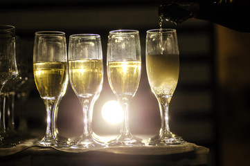 close up photo of glasses of champagne in the dark on the table