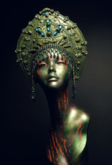 Black head of mannequin in decorated green kokoshnick, dark studio background