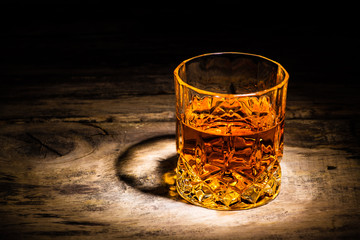 whiskey with ice cubes on wooden background