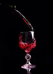 Red wine pouring into wine glass