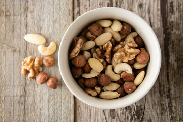 Nuts mix over wooden background. Energy super food. Proteine food. dieting, healthy food. Isolated nuts - almonds, hazelnuts,cashew, brazil nuts.