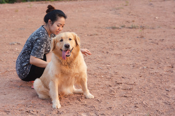 Woman with her golden retriever dog playing outdoors.
