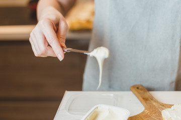 Melted cream cheese on a cook's knife flows down