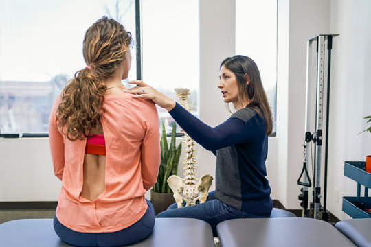 Physiotherapist talking with patient about spine injury