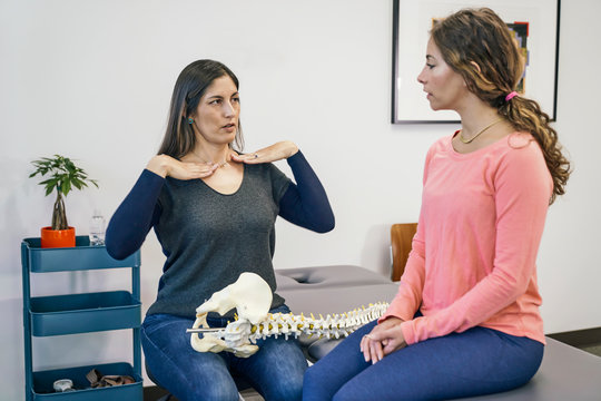 Physiotherapist talking with patient about spine injury