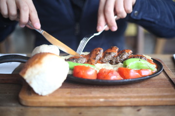 eating meat dish with cutlery