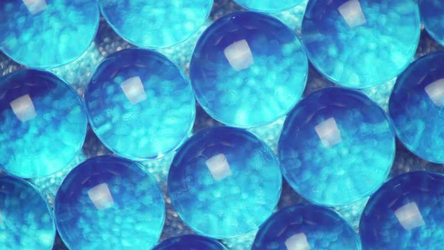 Blue hydrogel balls rotate on blue background