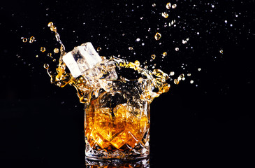 whiskey with splash on black background, brandy in a glass
