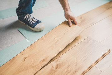 A man worker lays laminate - professional construction and finishing services