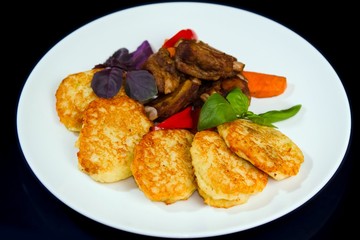 fried potato pancakes, barbecued pork ribs, served with basil, grilled carrots and paprika, restaurant menu photo