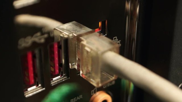 The person connects the Internet cable to the computer port