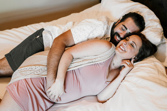 Smiling couple laying on bed at home