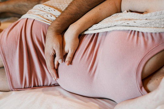 Midsection of couple laying on bed