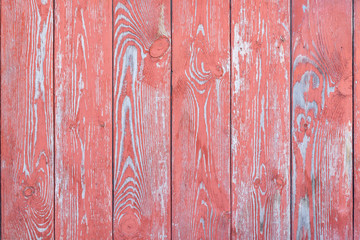 The texture of the wooden wall is red with peeling paint