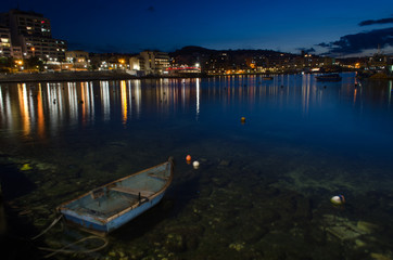 Fototapeta premium Beautiful night picture of Buġibba, St. Paul's Bay, a town in the Northern Region of Malta. Night lights of the city reflected in the sea.