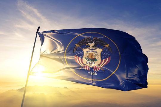 Utah state of United States flag waving on the top sunrise mist fog