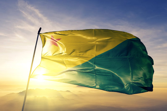 Acre state of Brazil flag waving on the top sunrise mist fog