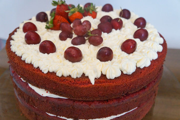 red velvet cake with red fruits (strawberries, grapes and cherries)