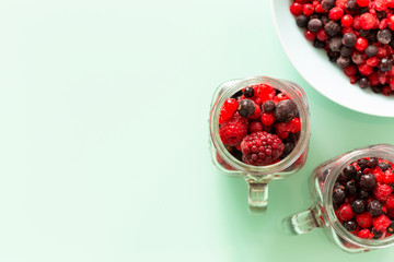 A healthy cocktail of forest fruits on a background of pastel green glass top, Empty space for an inscription