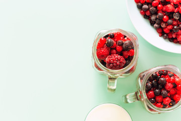 A healthy cocktail of forest fruits on a background of pastel green glass top, Empty space for an inscription