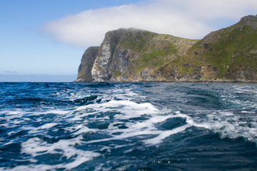 Fototapeta na wymiar Steilküste der norwegischen Insel Runde bei leicht bewölktem Himmel