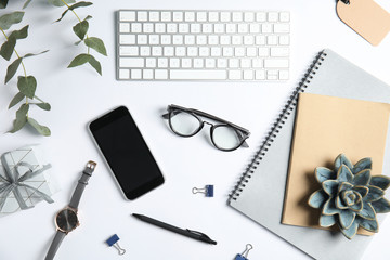 Flat lay composition with computer keyboard and mobile phone on white background. Blogger's workplace