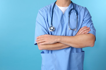Young medical student in uniform on color background, closeup. Space for text