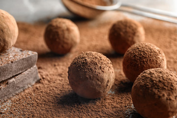 Sweet raw chocolate truffles powdered with cocoa on table