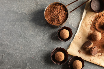 Flat lay composition with chocolate truffles on grey background, space for text