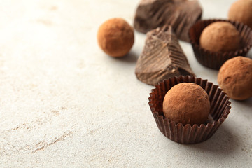 Tasty raw chocolate truffles on light background, space for text