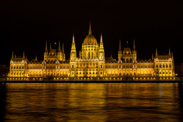 Fototapeta premium View on the The Hungarian Parliament Building, beside the Danube River. European travel. Night scene. Budapest. Hungarian landmarks.