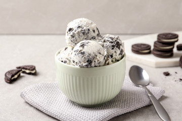 Bowl with ice cream and crumbled chocolate cookies on table