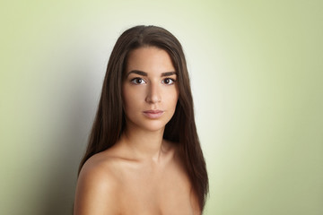 Studio portrait of a beautiful young woman with long brunette hair. Pretty spa model girl with perfect fresh clean skin. Skin care concept