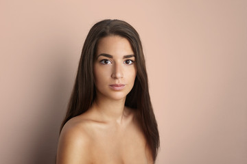 Naklejka premium Portrait of beautiful young happy smiling woman with long curly hair, over brown background.Vogue style portrait of beautiful delicate woman