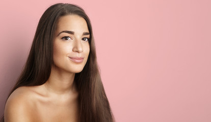 Fototapeta premium Pracowniany portret piękna młoda kobieta z długim brunetka włosy. Ładna dziewczyna modelu spa z doskonałą świeżą czystą skórę. Koncepcja pielęgnacji skóry