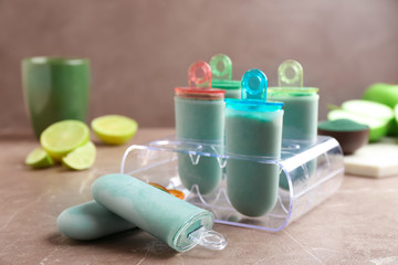 Delicious spirulina popsicles in ice cream mold on table