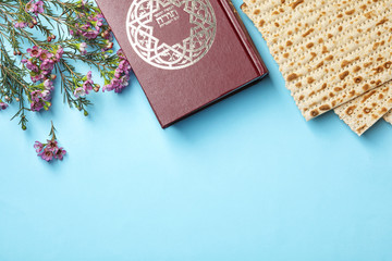 Flat lay composition with matzo and Torah on color background, space for text. Passover (Pesach) Seder