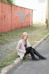 Beautiful girl sitting in front of shipping container