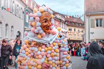Carnival figure with costume of balls. Street Carnival in Southern Germany - Black Forest.