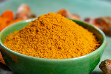 Fresh turmeric or curcuma root and dried powder, wildly used in Asia and India as spice, food ingredient and for medicinal purposes.