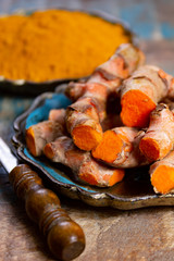 Fresh turmeric or curcuma root and dried powder, wildly used in Asia and India as spice, food ingredient and for medicinal purposes.