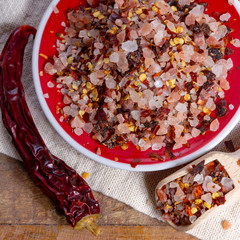 Gross sea salt mixed with dried red hot chili pepper, colorful seasoning close-up