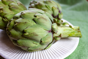 Obraz premium Heads of fresh uncooked artichoke flowers close up