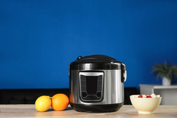 Modern multi cooker and ingredients on table in kitchen