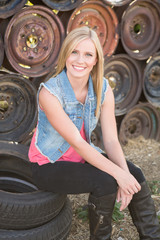 beautiful young girl posing in front of a wall fo auto wheels