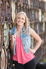 beautiful young girl posing in front of a wall fo auto wheels