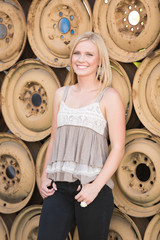 beautiful woman posting in front of a wall of wheels