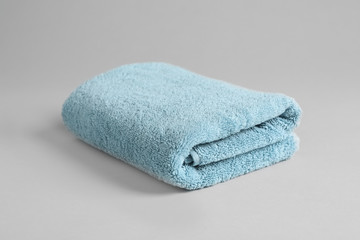 Fresh fluffy folded towel on grey background